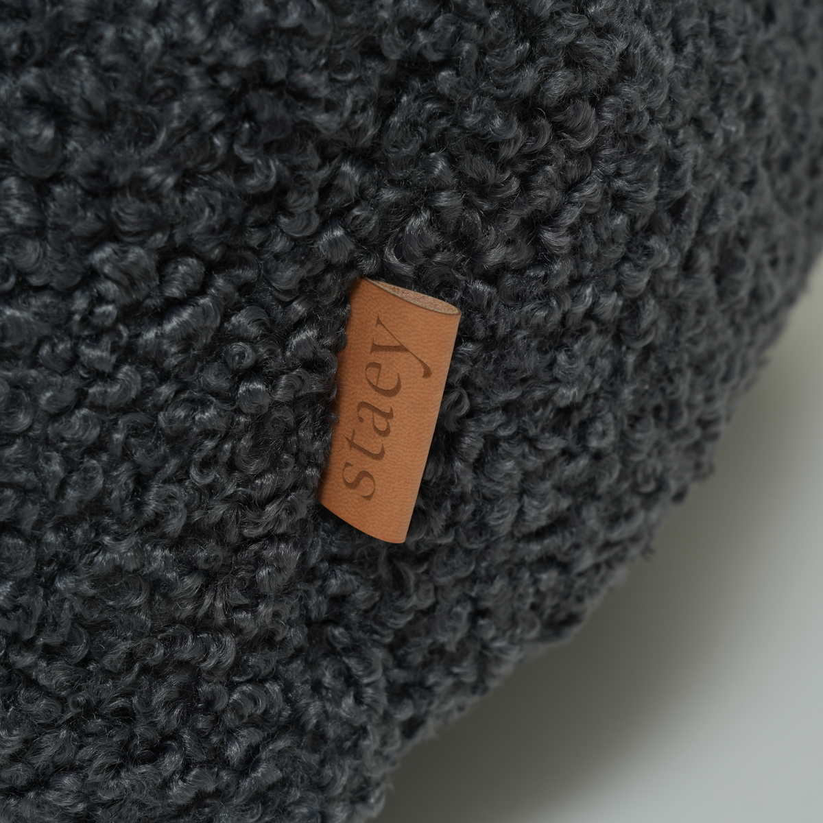 Close-up van het leren Staey-label op de ‘Storm Curly Bouclé’-hondenmand