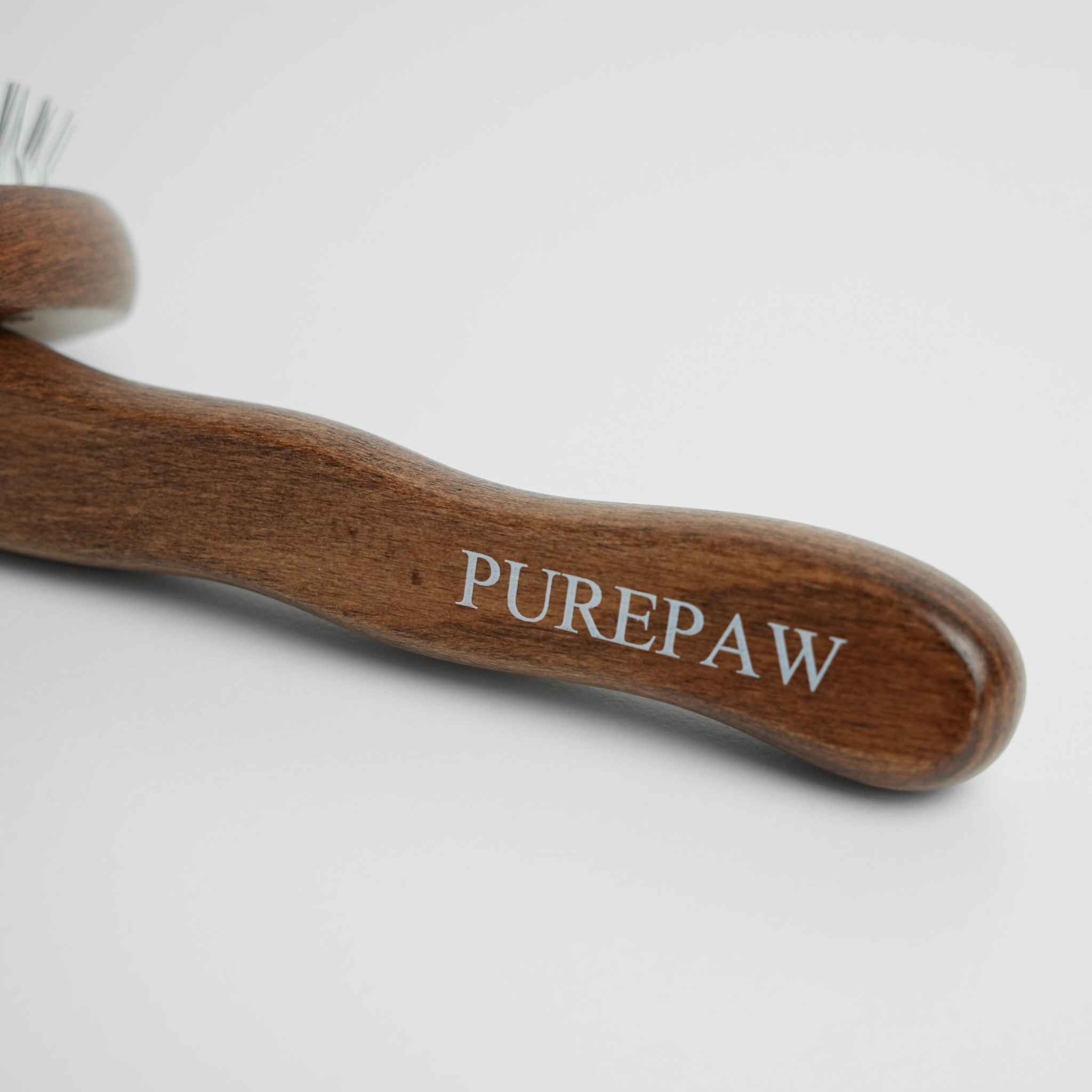 Brosse pour chien en bois avec le logo « PUREPAW » sur fond blanc