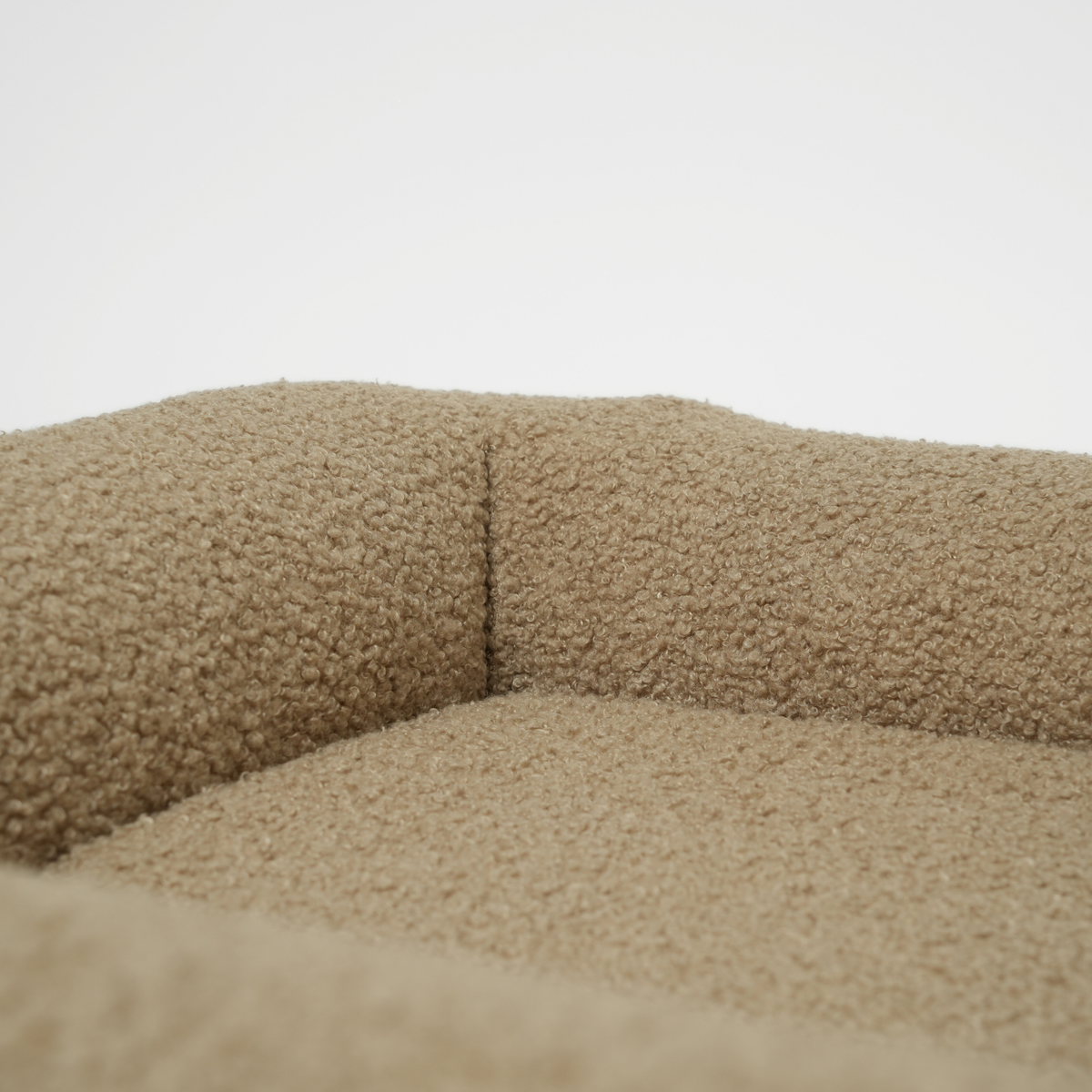 Gros plan sur le traversin et le coussin du lit pour chien en bouclé frisé couleur mousse