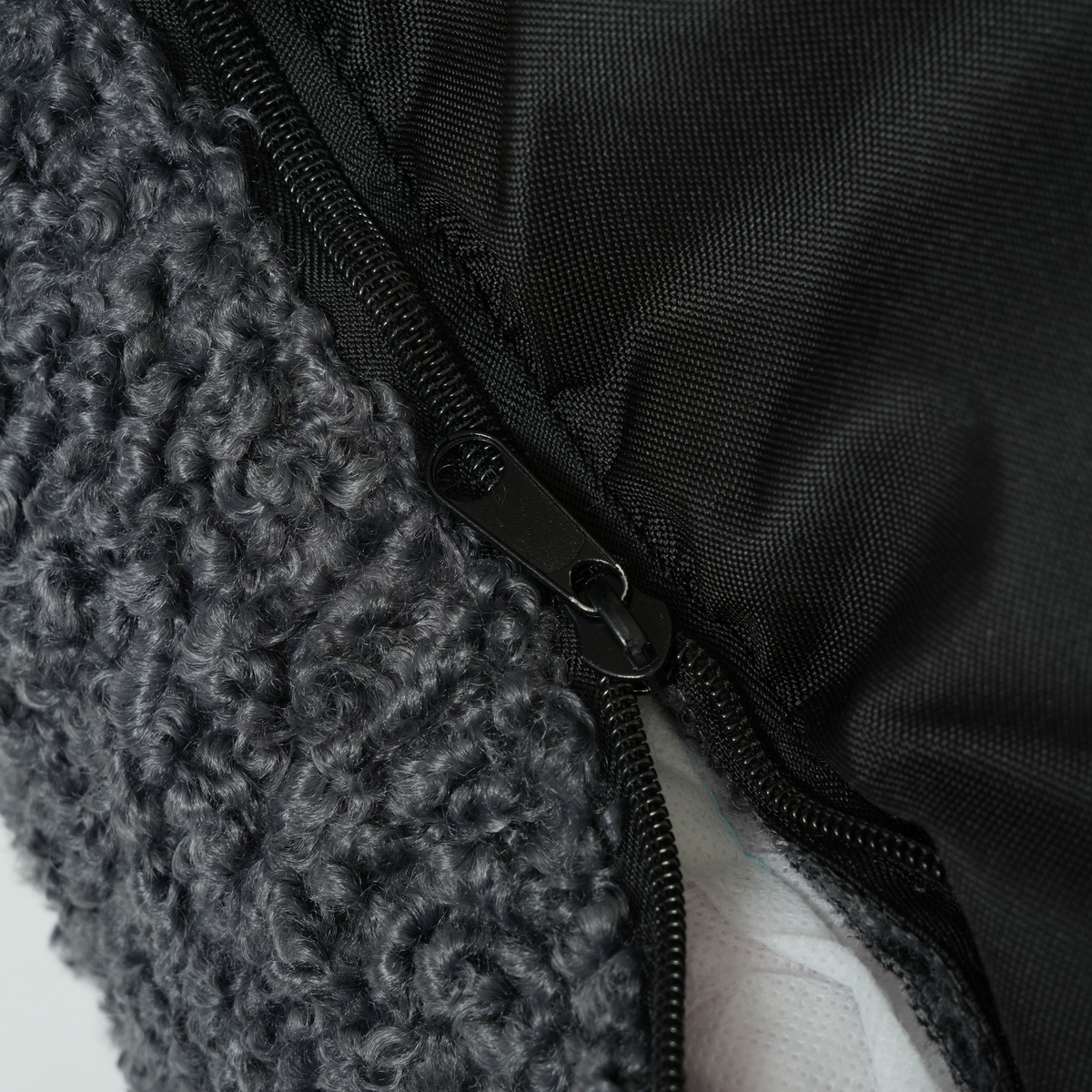Close-up van de ritssluiting en de antislipbodem van de ‘Storm Curly Bouclé’-hondenmand
