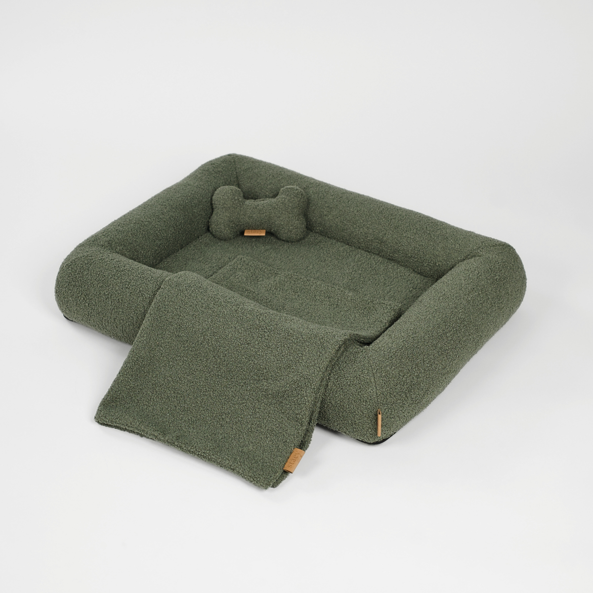 De moss green bouclé hondenmand met een botvormig kussen en een bijpassende mat