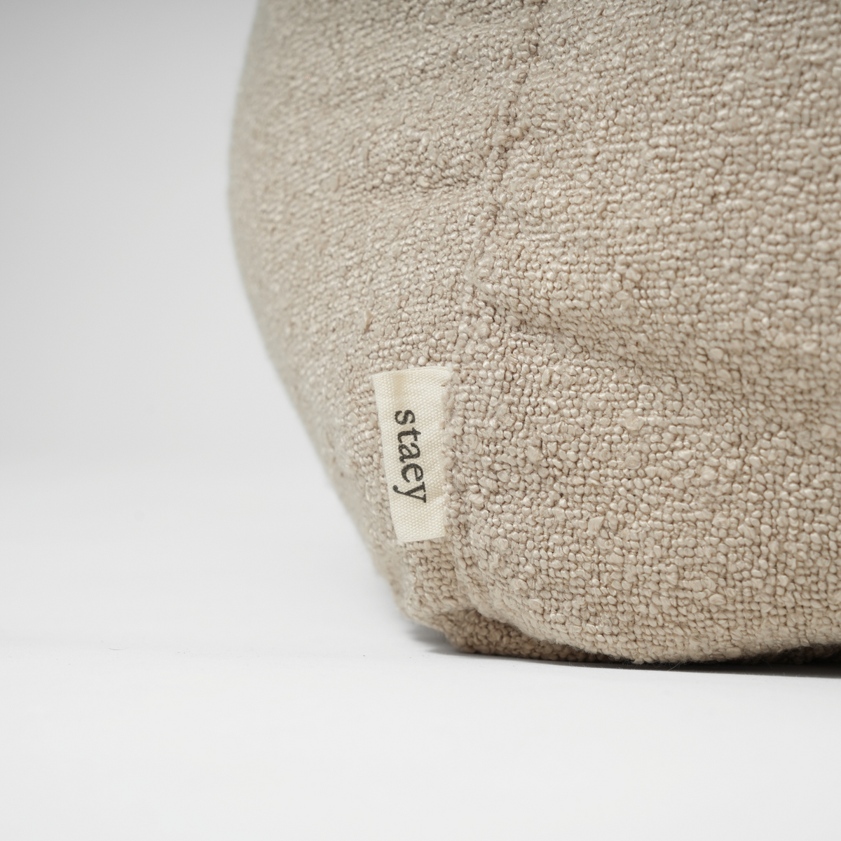 Close-up van het Staey-label op de hondenmand van oat bouclé