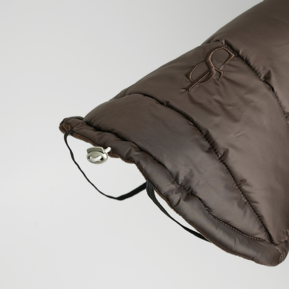 Close-up van de capuchon en het trekkoord van de hondenjas met espresso-quiltpatroon