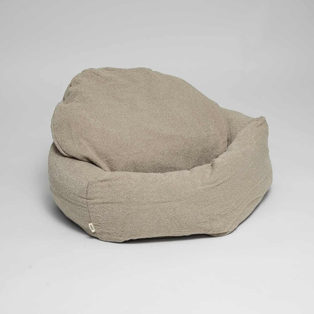 The oat bouclé Luna dog bed seen from the side