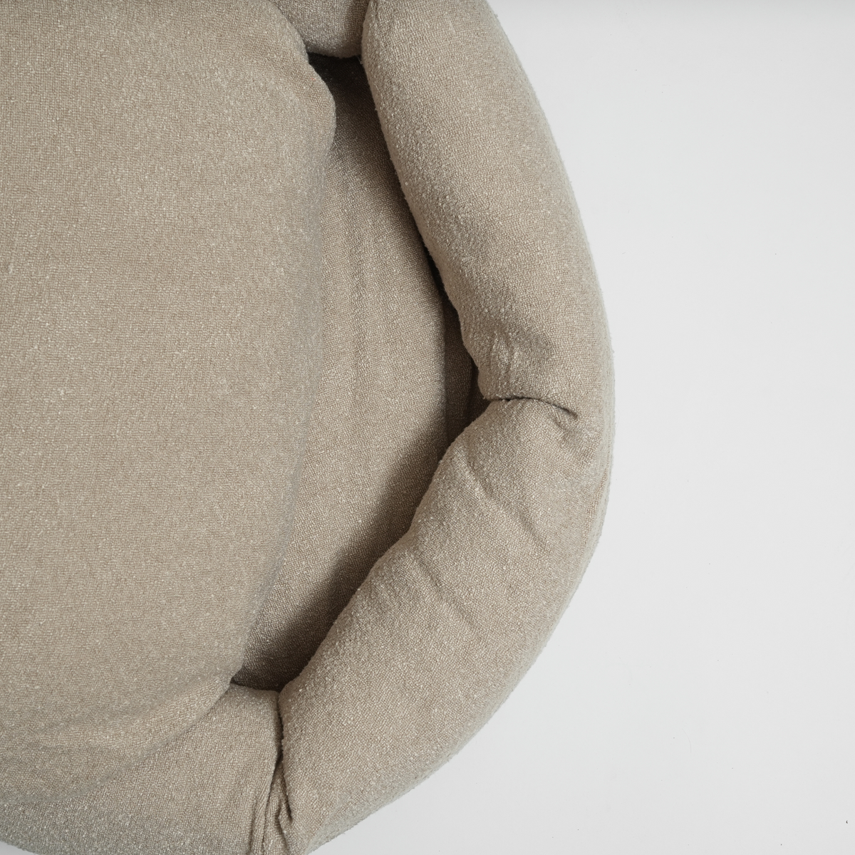 The oat bouclé Luna dog bed with its cushion, seen at an angle