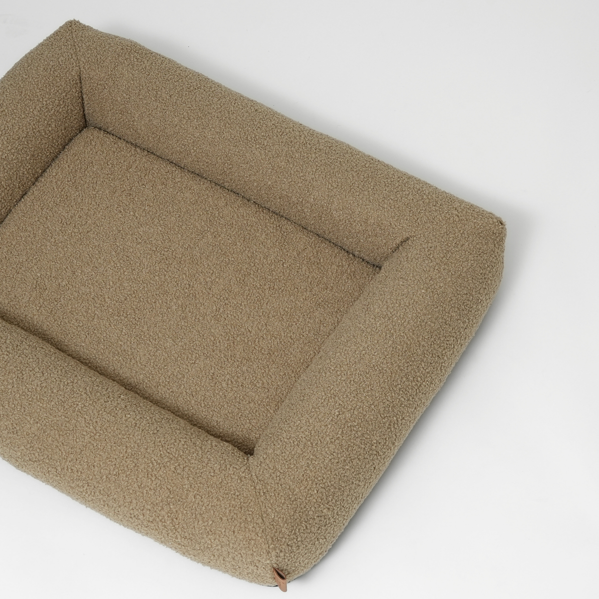 Le lit pour chien en bouclé frisé couleur mousse, vu sous un angle
