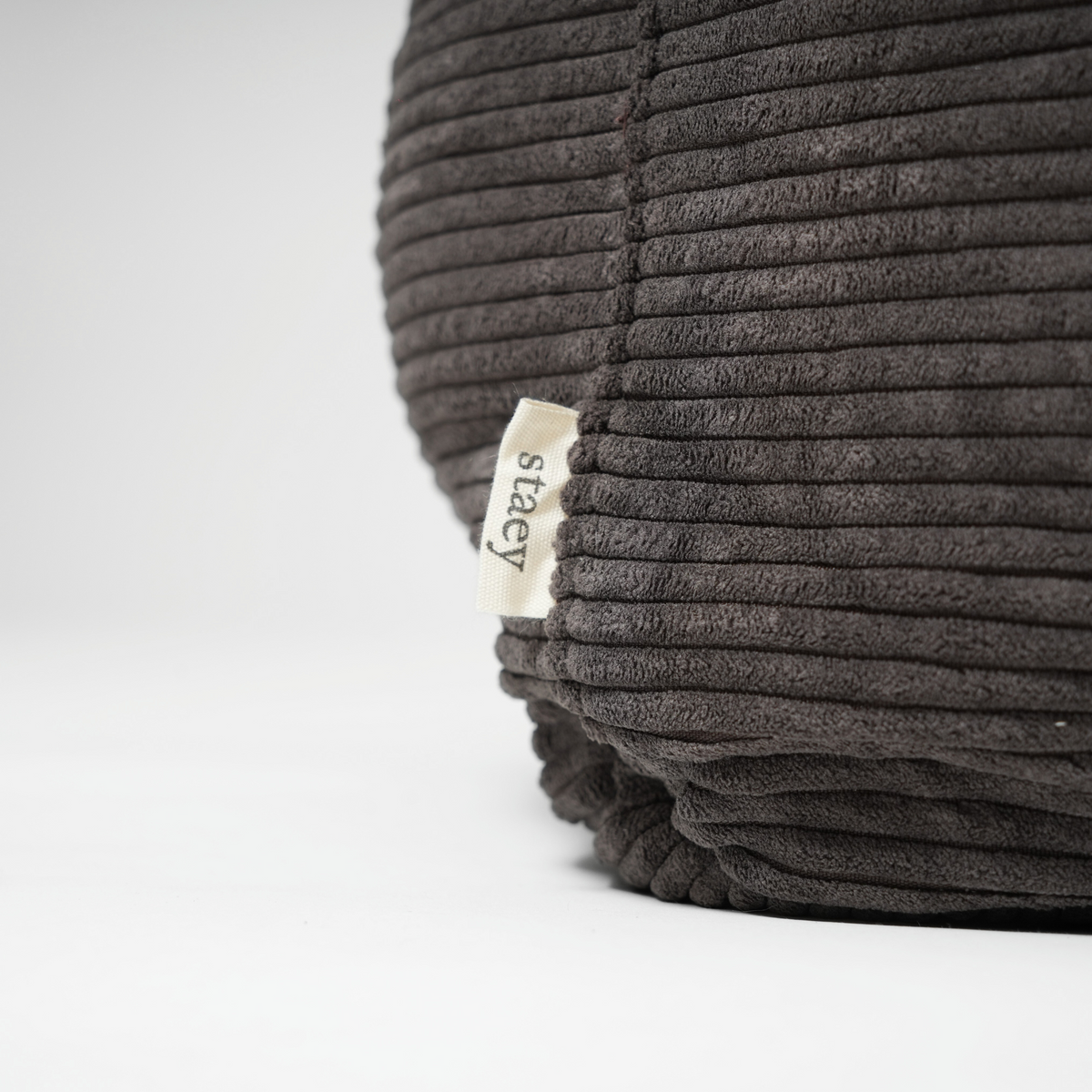 Close-up van het Staey-label op de hondenmand van antracietkleurig Corduroy