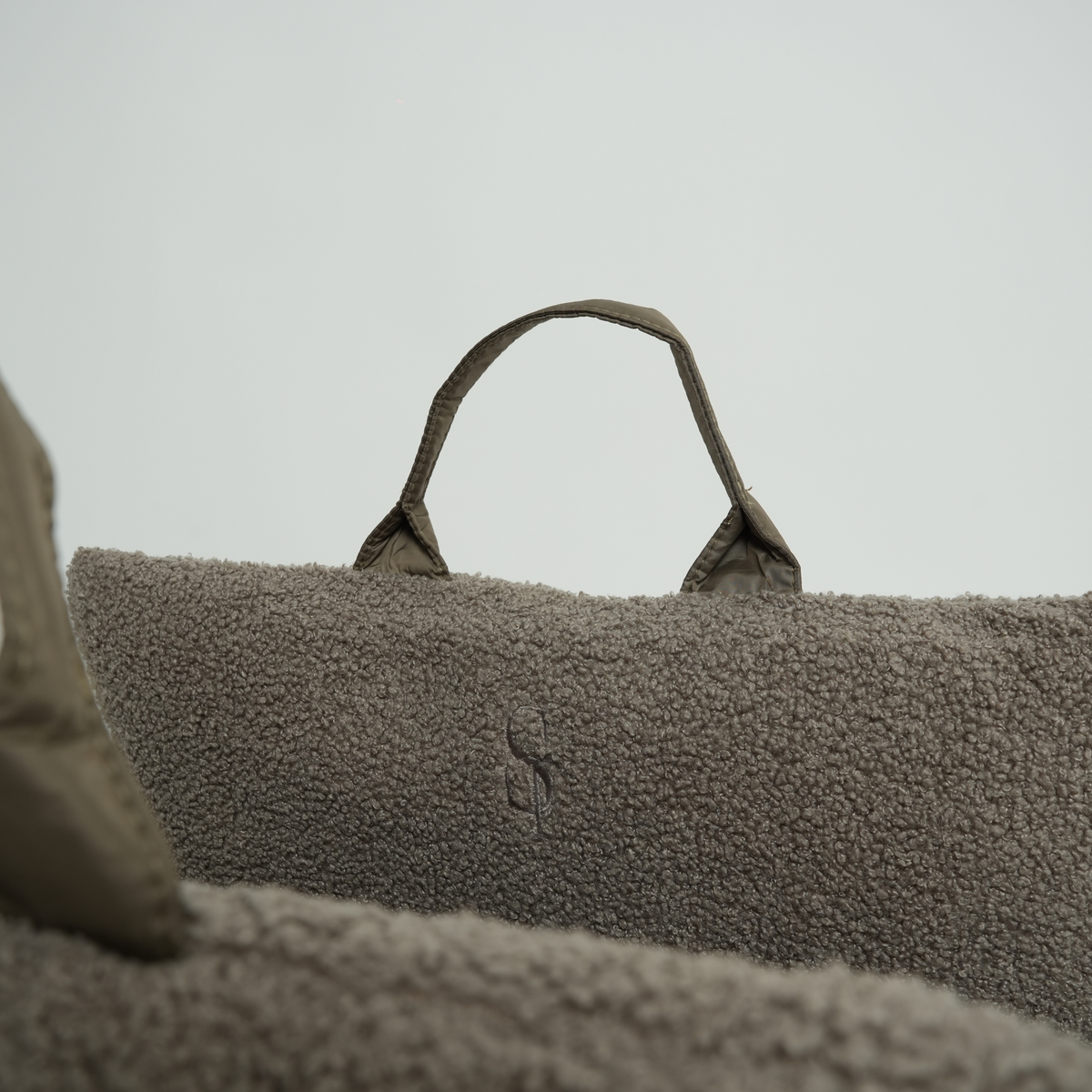 Close-up of the carry handle on the taupe bouclé dog car seat