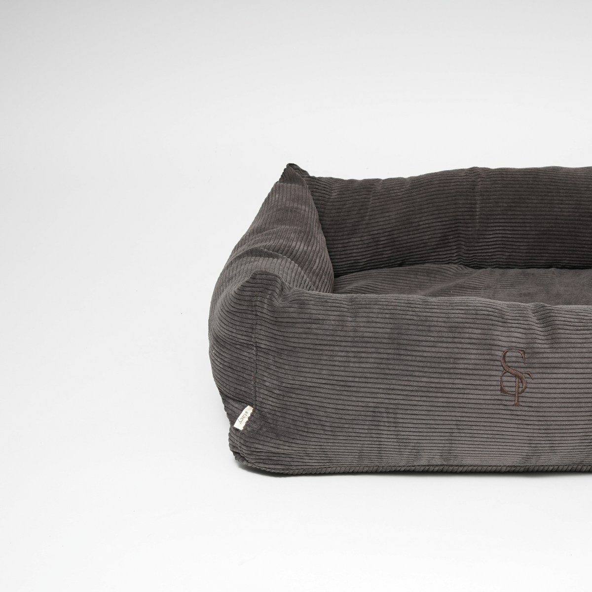De rechthoekige hondenmand van antracietkleurig Corduroy, vanuit een schuine hoek gezien
